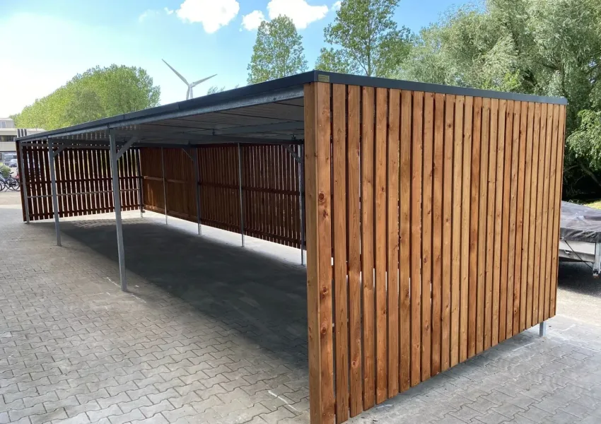 Zijaanzicht fietsenstalling met strakke daklijn en staalconstructie