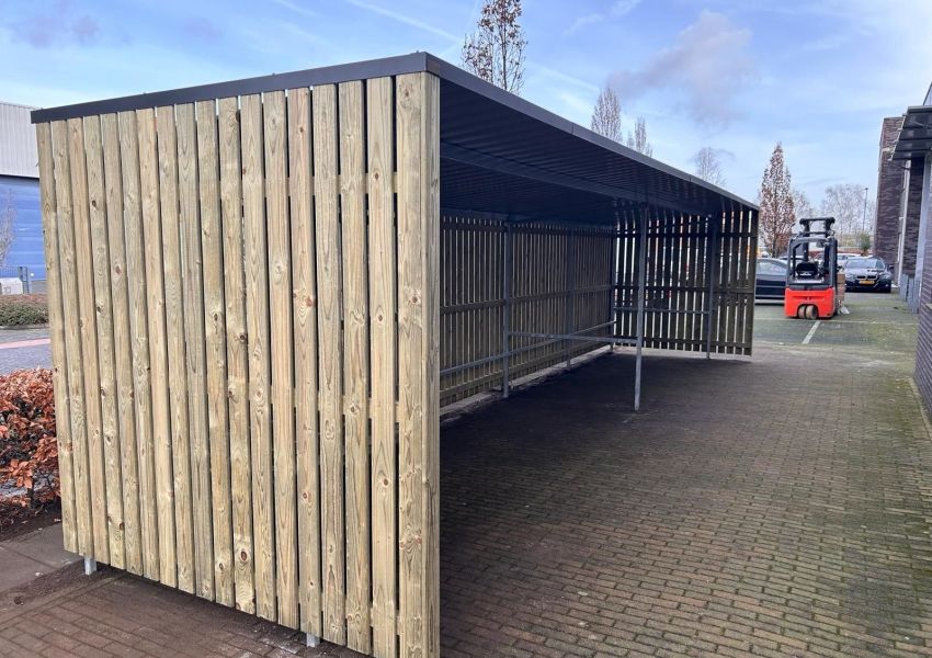 Stalen koker in achterwand voor het vastzetten van fietsen