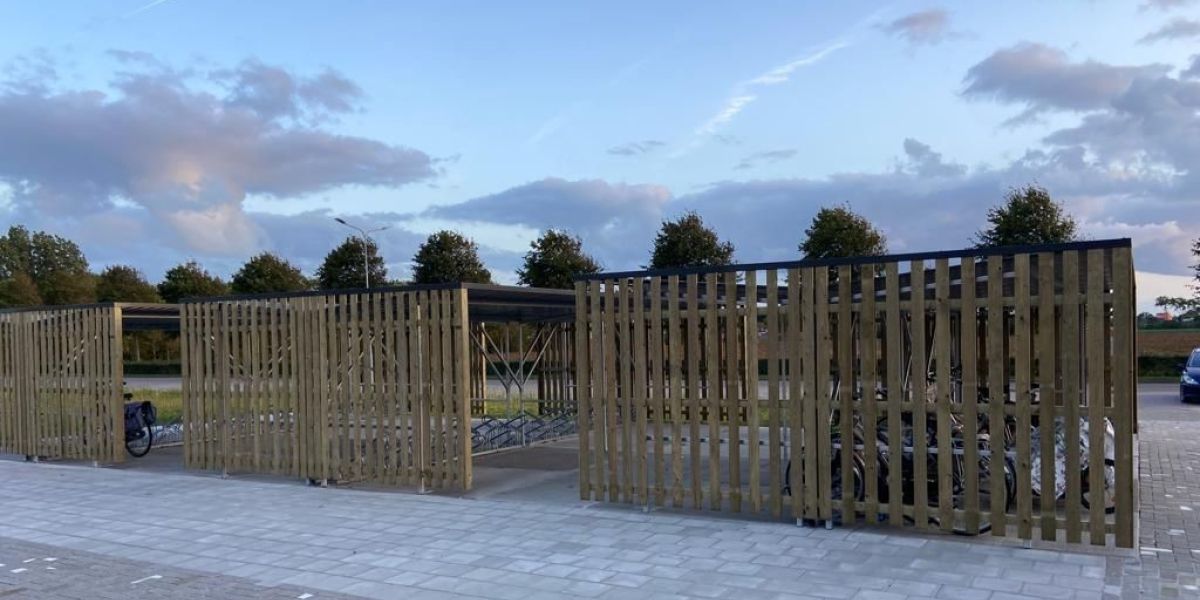 Overzicht van drie geplaatste fietsenstallingen met vurenhouten bekleding