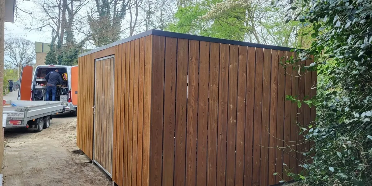 Voorzijde fietsenberging met deur van 115 cm breed