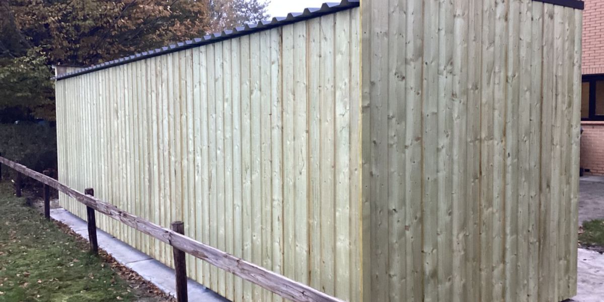 Fietsenstalling met open en gesloten gedeelte van hout en staal