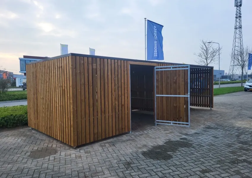 Overkapping naast afsluitbare fietsenberging met strakke bestrating