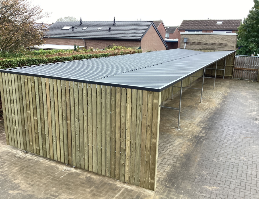 Open fietsoverkapping met ruimte voor meerdere fietsen bij een kantoor