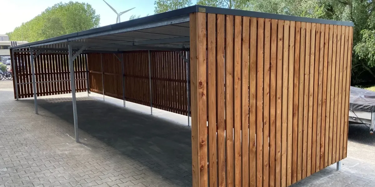 Zijaanzicht fietsenstalling met strakke daklijn en staalconstructie