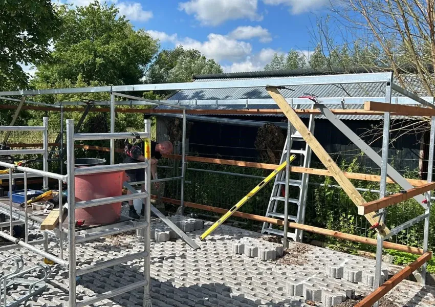 Stalling van vurenhout in Tanalith Tanatone kleur op betonpoeren