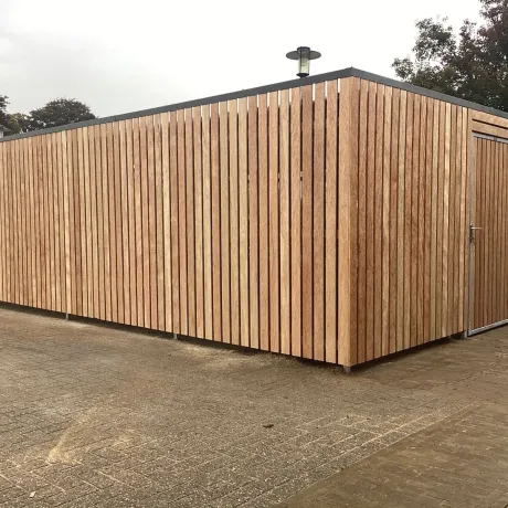 Gesloten fietsenstalling met deur van hout