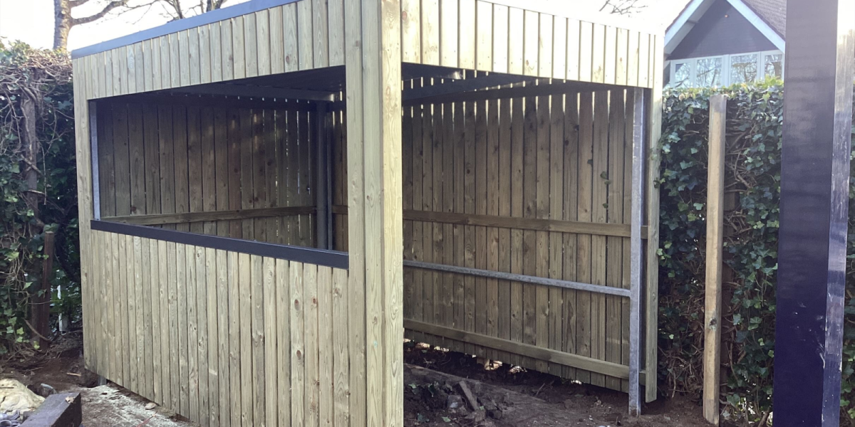 Overkapping met geïmpregneerde houten wanden en damwandplaat