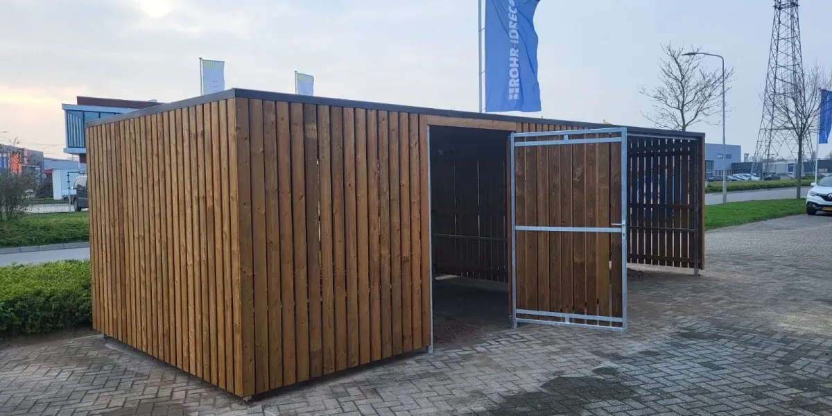 Overkapping naast afsluitbare fietsenberging met strakke bestrating