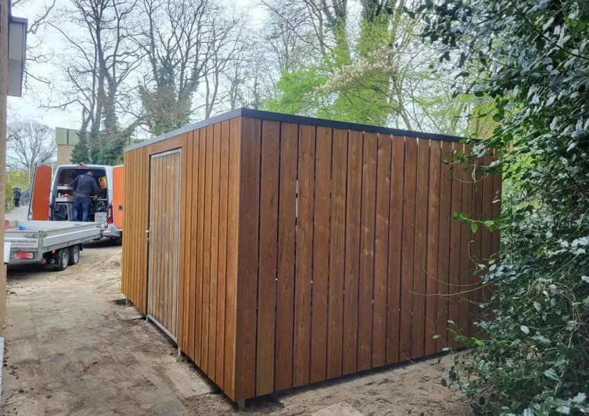 Voorzijde fietsenberging met deur van 115 cm breed