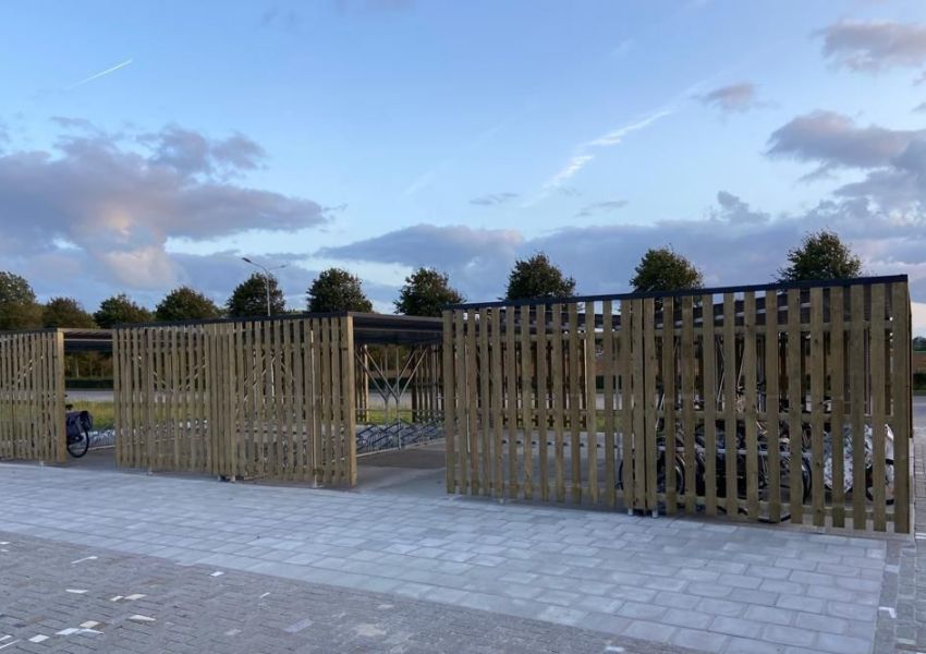 Overzicht van drie geplaatste fietsenstallingen met vurenhouten bekleding