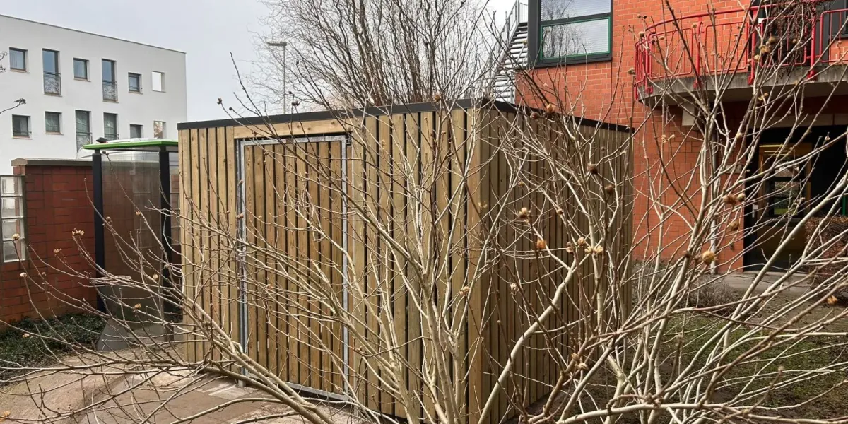 Fietsenstalling met houten draaideur en hang- en sluitwerk