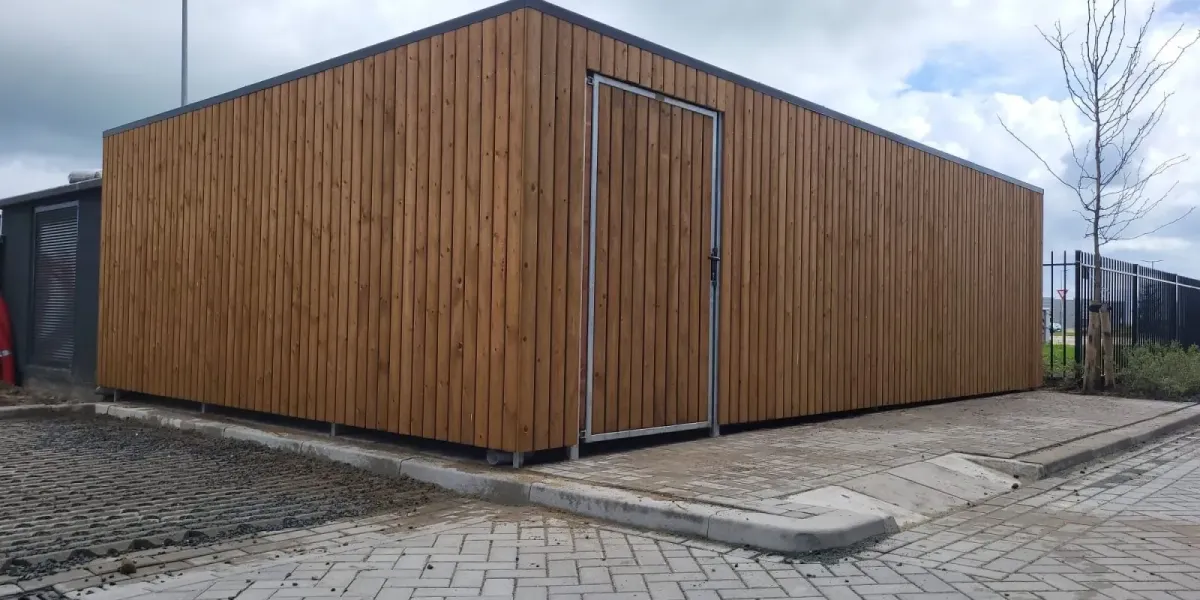 Zijaanzicht van afsluitbare fietsenstalling met naar binnendraaiende deur