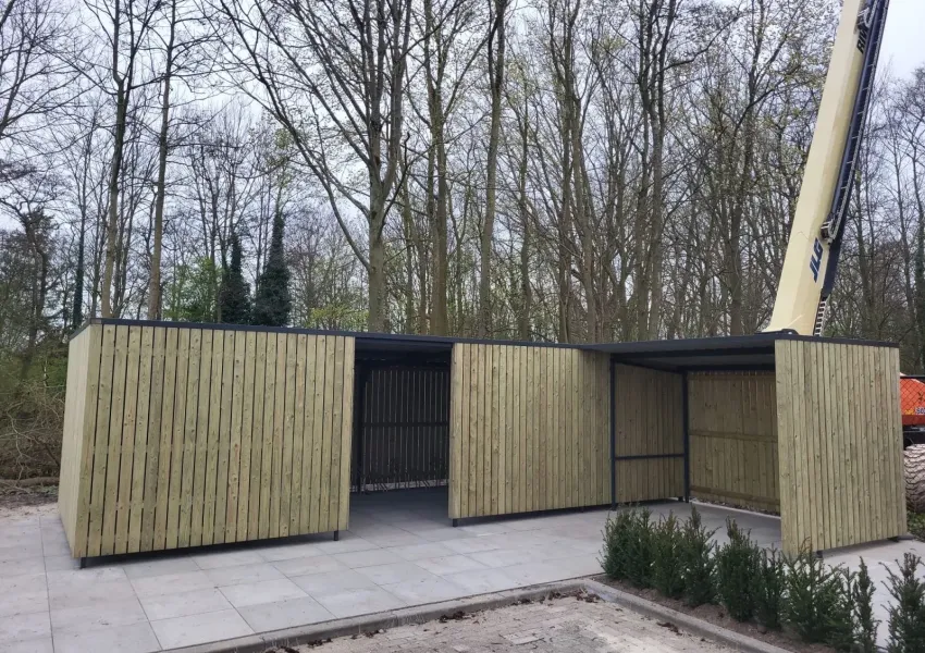 Overkapping naast fietsenstalling met inpandige dakgoot en damwandplaten