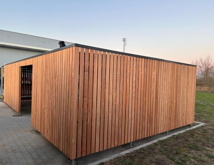 Fietsoverkapping met afsluitbare deuren naast bedrijfspand