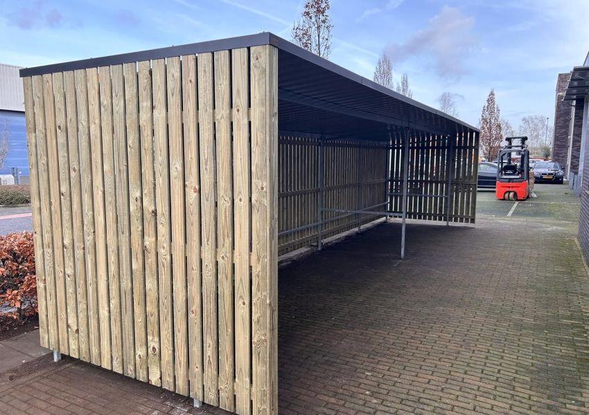 Stalen koker in achterwand voor het vastzetten van fietsen
