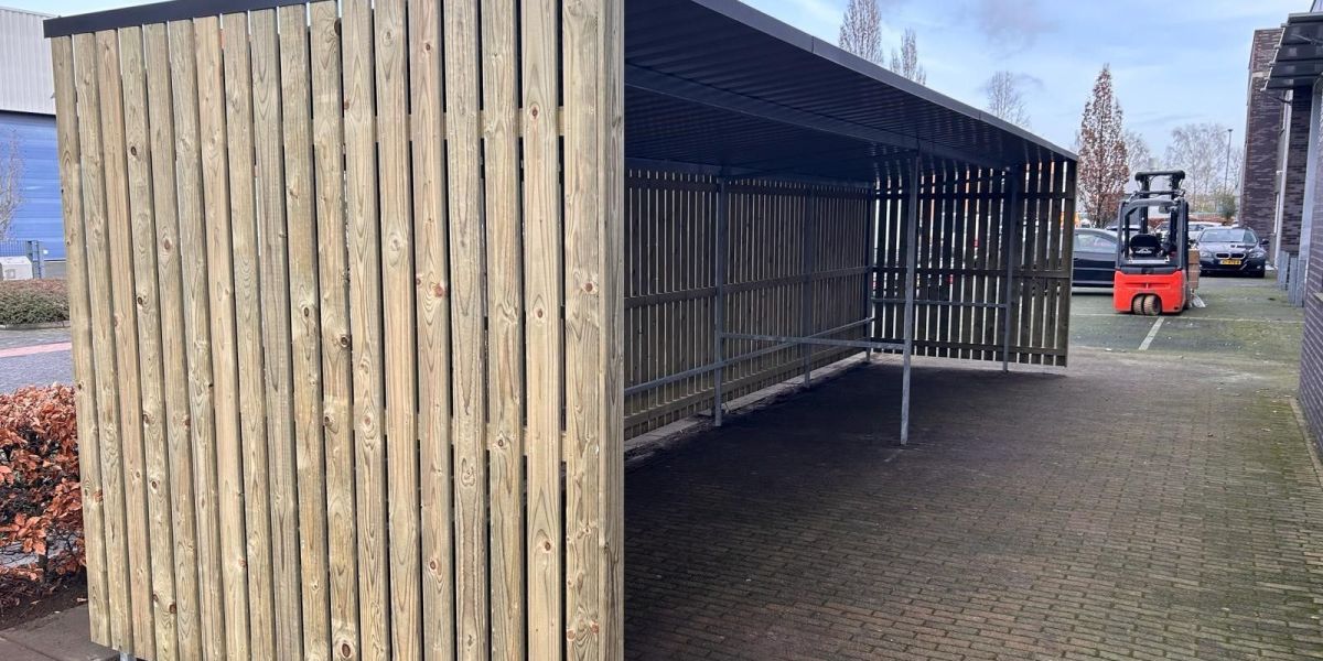 Stalen koker in achterwand voor het vastzetten van fietsen