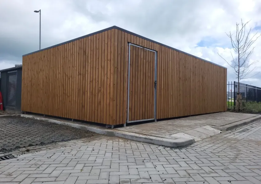 Zijaanzicht van afsluitbare fietsenstalling met naar binnendraaiende deur